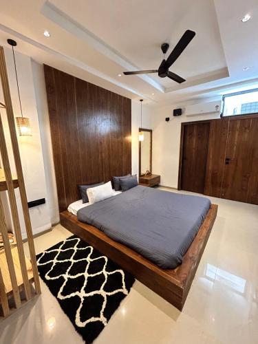 a bedroom with a bed with a ceiling fan at Andaz Luxe Apartment. in Indore