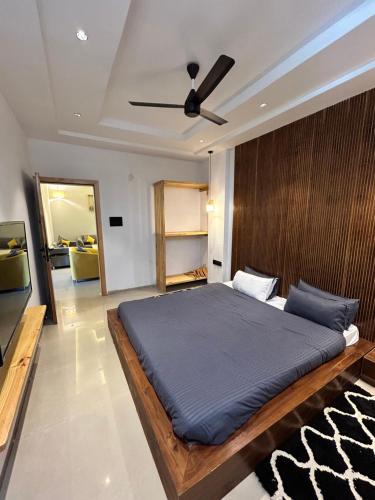 a bedroom with a large bed with a ceiling fan at Andaz Luxe Apartment. in Indore