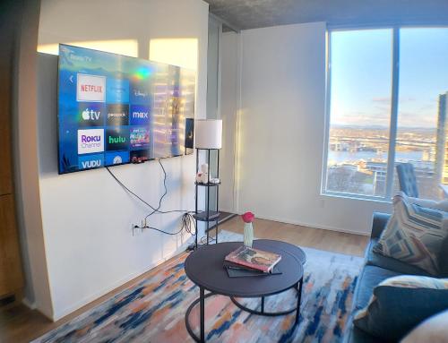 a living room with a table and a tv on a wall at City Views & Downtown Bliss in Portland