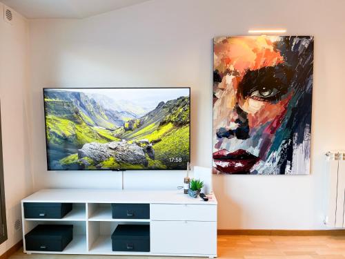 una sala de estar con TV y una pintura en la pared en Vistas&Luz Zona Lycee 5 minutos al centro en Andorra la Vella