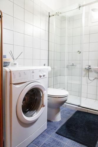 a bathroom with a washing machine and a toilet at Unique Apartment in Alexandroupoli
