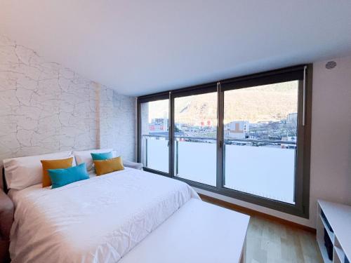 a bedroom with a white bed and a large window at Vistas&Luz Zona Lycee 5 minutos al centro in Andorra la Vella