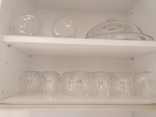 a shelf with glasses and a tea pot on it at Superbe appartement JO 2024 in Plaisir