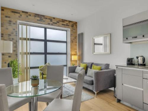 cocina y sala de estar con mesa de cristal en Apartment Regents Park Serviced Apartment-2 by Interhome, en Londres