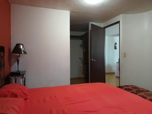 a bedroom with a bed with a red blanket at Departamento Céntrico CDMX in Mexico City