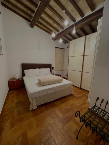 a bedroom with a white bed and a wooden floor at GG Apartments Assisi in Assisi