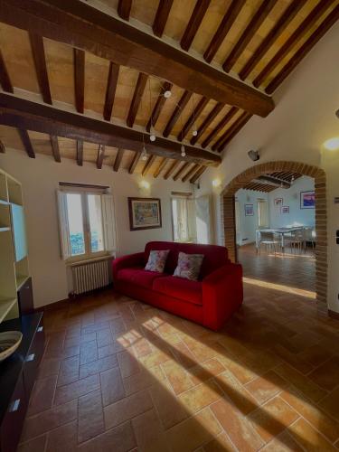 ein Wohnzimmer mit einem roten Sofa und einem Tisch in der Unterkunft GG Apartments Assisi in Assisi