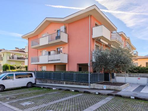 un bâtiment avec une camionnette blanche garée devant lui dans l'établissement Apartment Garden Apartment by Interhome, à Riva del Garda