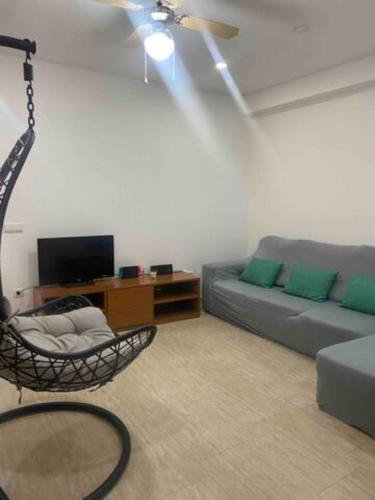 uma sala de estar com um sofá e um baloiço em Nazaré Three Fish na Nazaré