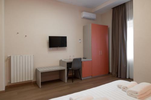 a bedroom with a desk and a computer in it at THE SUN HOTEL BOUTIQUE NAPOLI in Naples