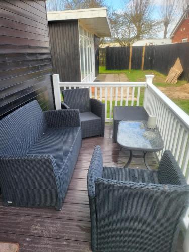 a patio with two chairs and a table on a deck at 116 cherry park in Chapel Saint Leonards