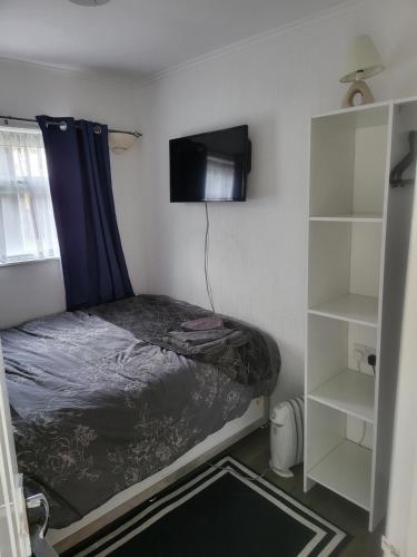 a small bedroom with a bed and a tv at 116 cherry park in Chapel Saint Leonards