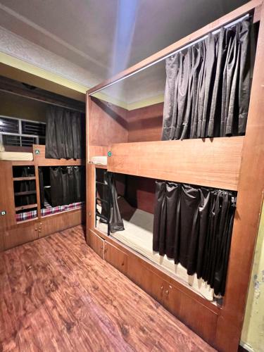 a walk in closet with black curtains and wooden floors at Trekkers Home in Kathmandu