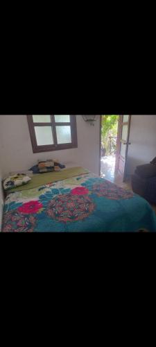 Un dormitorio con una cama con una manta de colores. en Hotel San Antonio, en San Juan La Laguna