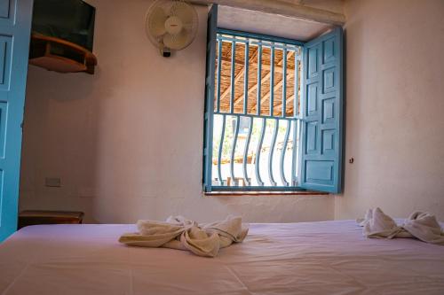 a bed with towels on it in a room with a window at Aura Hotel Parque Barichara By Infinity in Barichara
