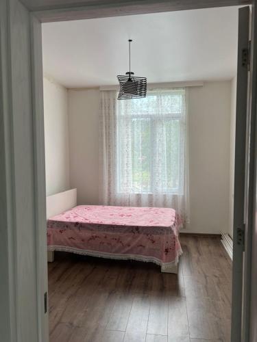 a bedroom with a pink bed and a window at Rcheuli Villa in Charnali in Batumi