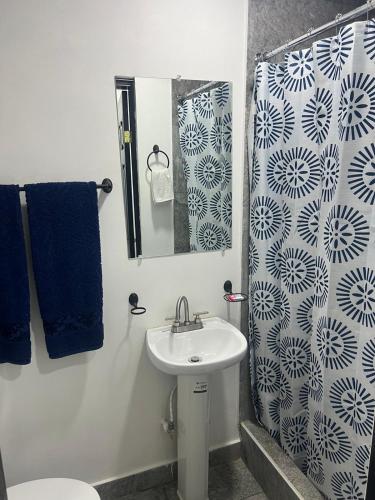 a bathroom with a sink and a toilet and a mirror at HOTEL and Suites Cananea in Cananea