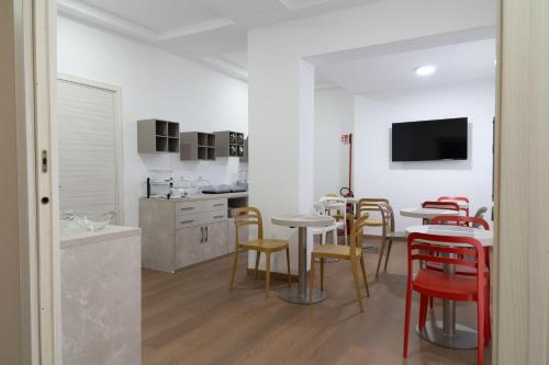 a room with tables and chairs and a kitchen at THE SUN HOTEL BOUTIQUE NAPOLI in Naples
