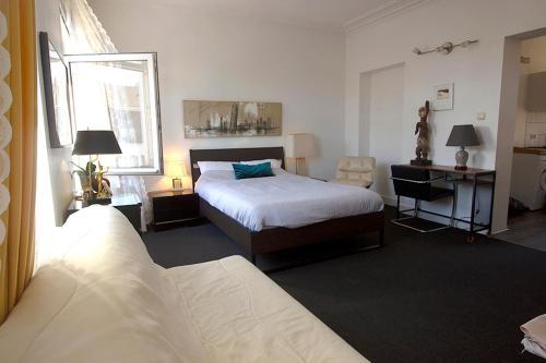 ein Hotelzimmer mit einem Bett, einem Schreibtisch und einem Fenster in der Unterkunft Handy Studio near Nato in Brüssel