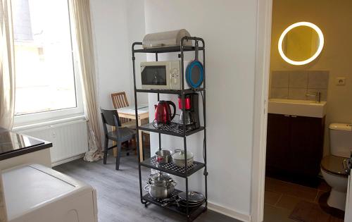 Zimmer mit einer Küche mit einer Mikrowelle auf einem Regal in der Unterkunft Handy Studio near Nato in Brüssel