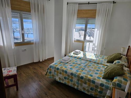 ein Schlafzimmer mit einem Bett und einigen Fenstern in der Unterkunft Casa Albino in Sanxenxo