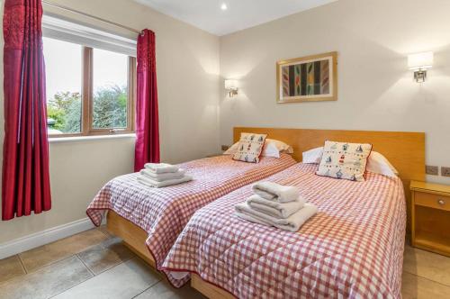 a bedroom with two beds with towels on them at Middleton Cottages in Yarm