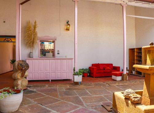 a living room with a red couch and a red chair at Aura Hotel Parque Barichara By Infinity in Barichara