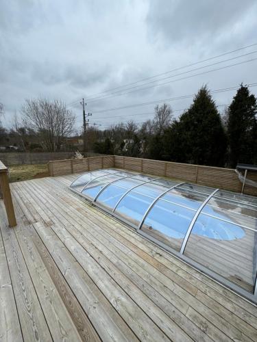 a swimming pool with a ramp on a wooden deck at The Cheerful Villa In Perstorp in Perstorp