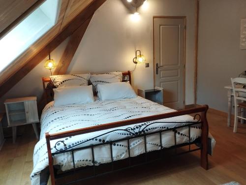 a bedroom with a bed in a attic at Au Pans de Bois. Repos et Détente in Auxon