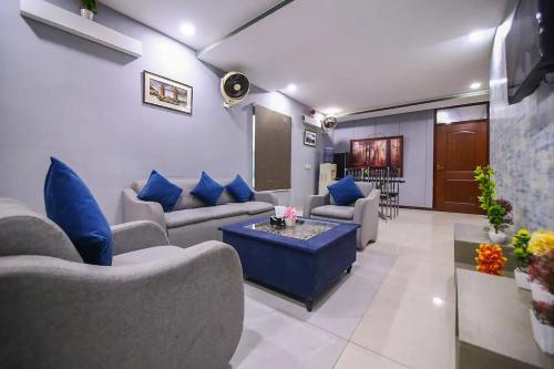 a living room with couches and blue pillows at Private 2BD Apartment Opposite Dha Phase 8 in Lahore