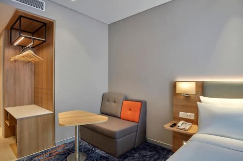 a room with a bed and a desk and a chair at Holiday Inn Express Bengaluru Bommasandra by IHG in Bengaluru