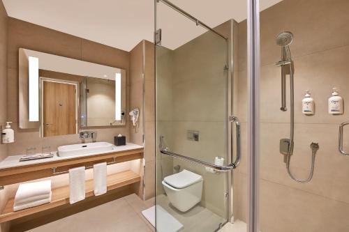 ein Bad mit einer Dusche, einem WC und einem Waschbecken in der Unterkunft Holiday Inn Express Bengaluru Bommasandra, an IHG Hotel in Bangalore