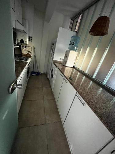 a kitchen with white cabinets and a counter top at Scout Apartament in Pilar