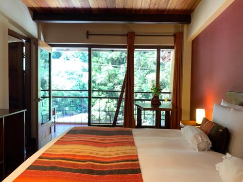 a bedroom with a large bed and a large window at Panorama B&B in Machu Picchu