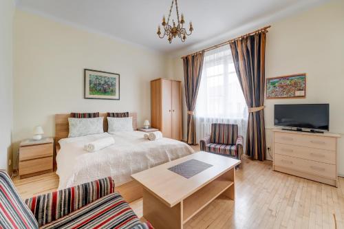 a bedroom with a bed and a tv and a table at Old Town Apartment Antokolskio in Vilnius