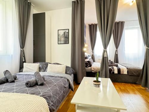 um quarto com 2 camas e uma mesa branca em New modern-style apartment with balcony in the Prague 2 em Praga