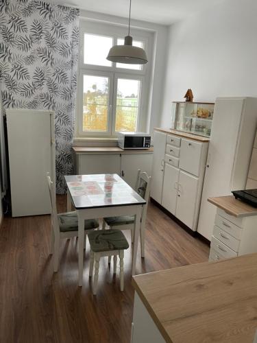 kuchnia ze stołem, stołem i krzesłami w obiekcie Apartament Koszary w mieście Strzelce Opolskie