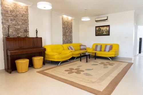 sala de estar con muebles de color amarillo y piano en Casa Moderna cerca de la PLAYA, en Castellón de la Plana