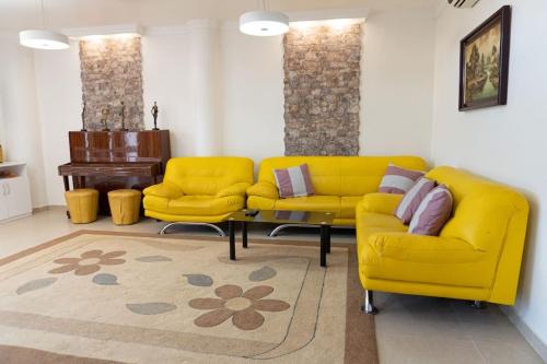 a living room with two yellow couches and a table at Casa Moderna cerca de la PLAYA in Castellón de la Plana