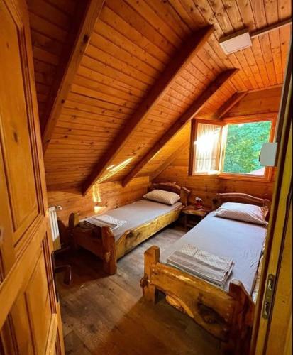 - une chambre avec 2 lits dans une cabane en bois dans l'établissement Etno kuća Mezul, 