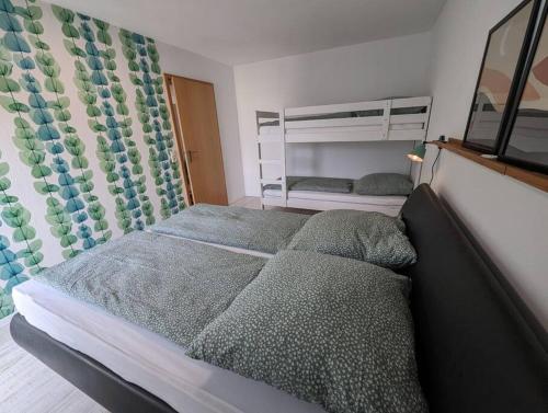 een slaapkamer met 2 bedden en een stapelbed bij ApartmentLochbrücke in Meckenbeuren