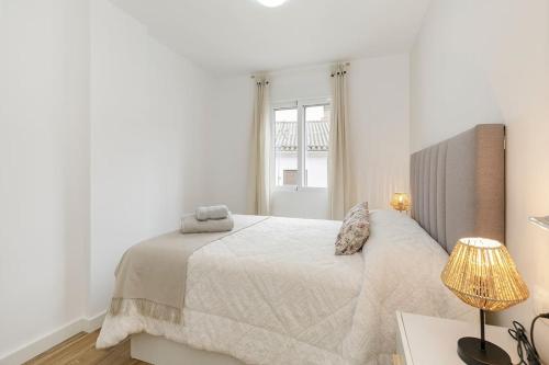 - une chambre blanche avec un lit et une fenêtre dans l'établissement Apartamento Carmela, à Monachil