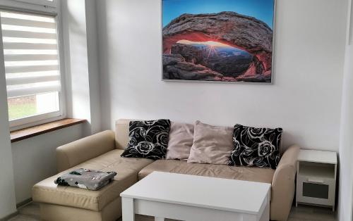 uma sala de estar com um sofá e uma mesa em Kawalerka blisko GÓR em Głuchołazy