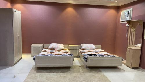 two beds in a room with a wall at شقة فندقية in Al Madinah
