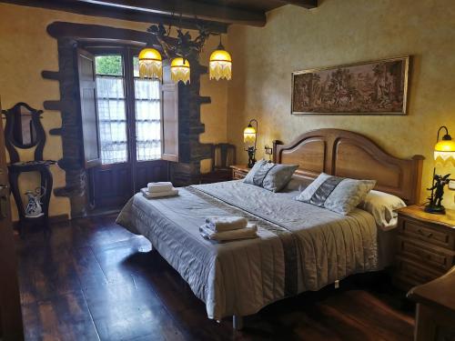 a bedroom with a large bed with two towels on it at Habitación Cuadruple con derecho a Barbacoa y patio in Navia de Suarna