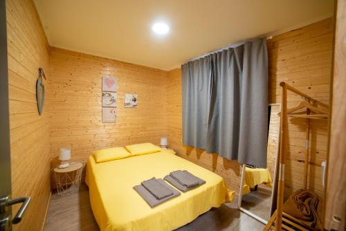 a bedroom with a yellow bed with towels on it at Chalet d'Aroeira in Corroios