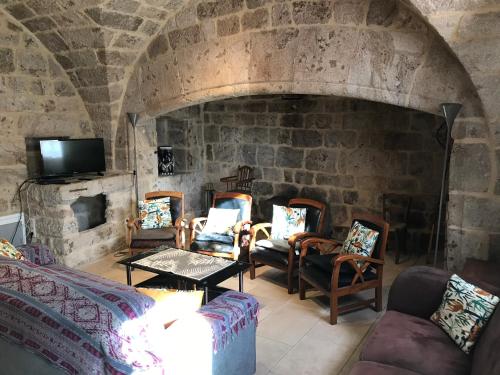 a living room with chairs and a stone fireplace at Gite La Framboise in Burzet