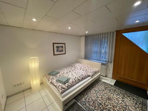 una piccola camera con letto e lampada di Apartment in Natur und Flughafen Nähe a Norimberga