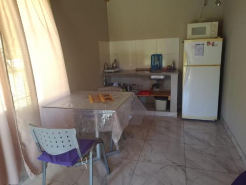 a kitchen with a table and a white refrigerator at Nuestro Sueño in Tandil