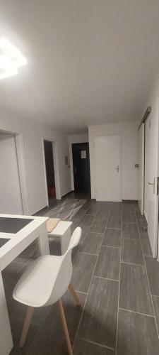 an empty room with a white chair and a table at FeWo3& Bad Wurzach in Bad Wurzach